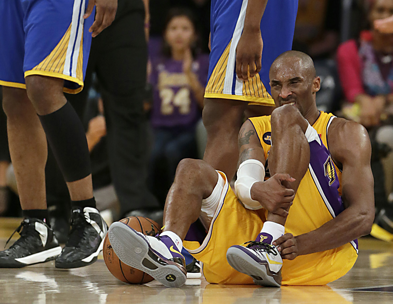 Kobe Bryant writhes in pain on the court late in the game against the Warriors at Staples Center.